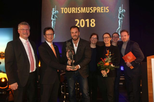 Dominic Boeer (Mitte) nimmt den 9. Tourismuspreis MV für die SOKU Wismar entgegen.